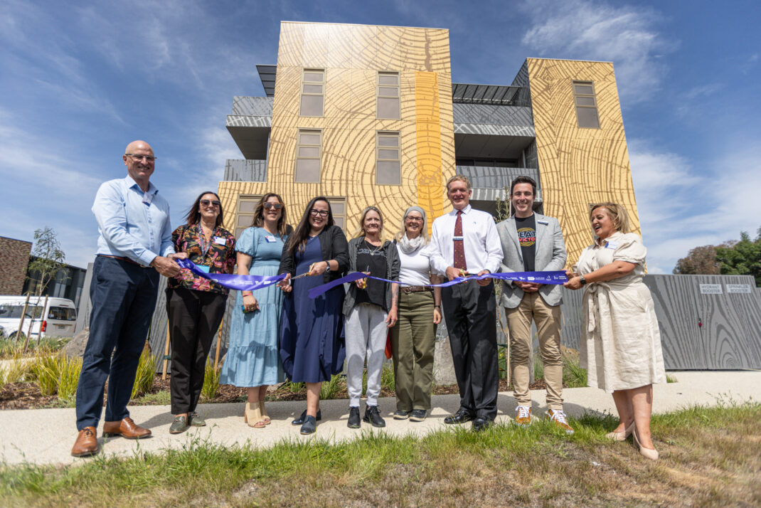 Kylie joins Launch Housing staff and local and state government politicians in a ribbon-cutting ceremony at the opening of her new apartment at Bellfield.